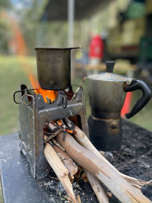 Cooka Camp Stove in use with coffee pot over open fire outdoors